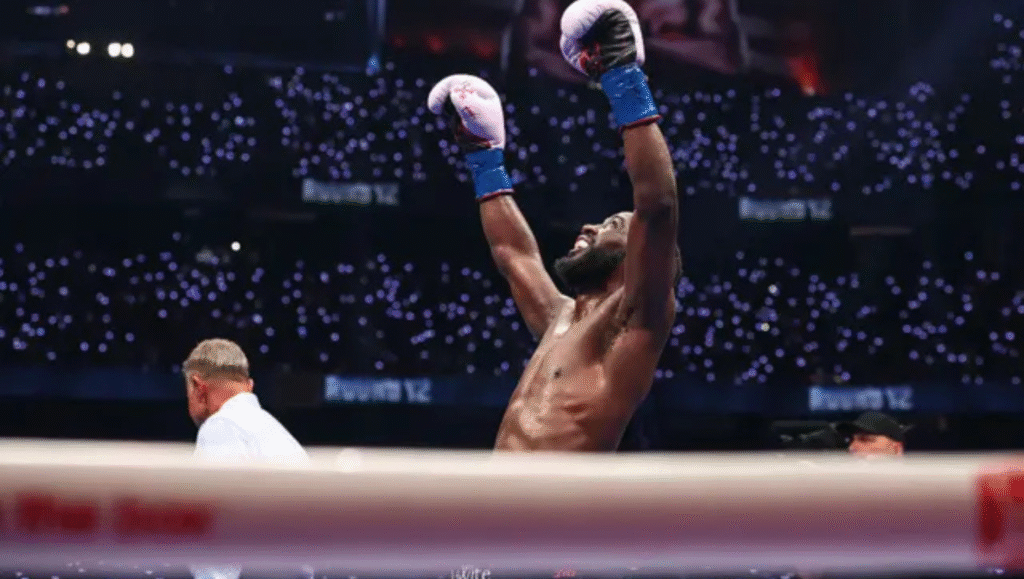 Terence Crawford campione indiscusso celebra vittoria con braccia alzate nel ring di Las Vegas, pantaloncini oro e blu, pubblico stadio sullo sfondo