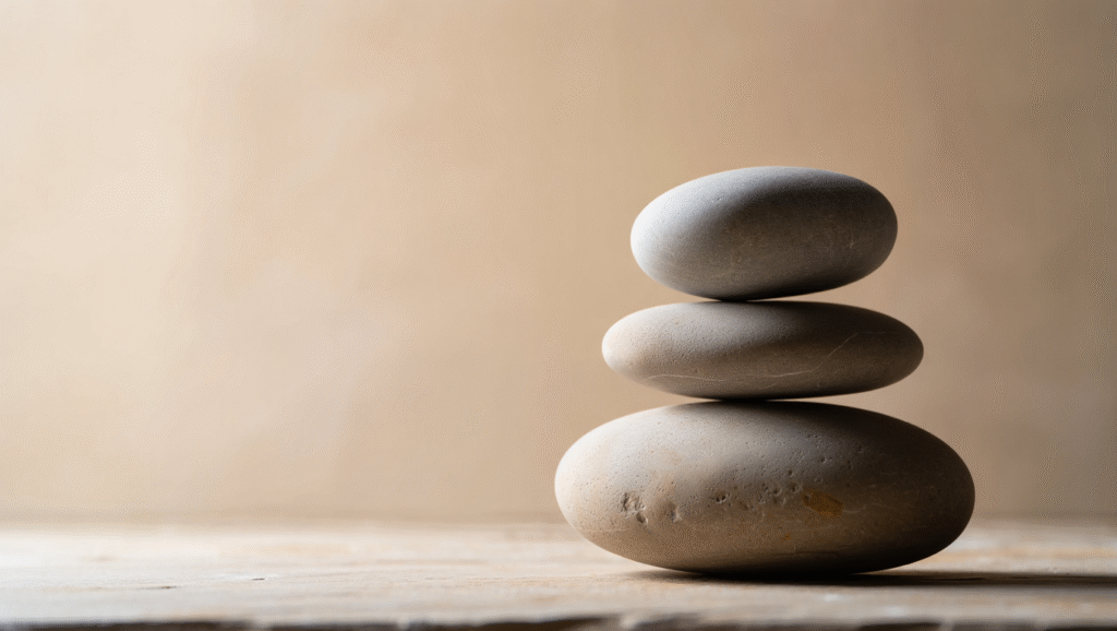 Pietre impilate in equilibrio perfetto che simboleggiano pazienza strategica e crescita personale costante