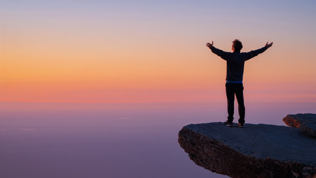 Trasformare la solitudine in forza - uomo con braccia aperte su scogliera al tramonto