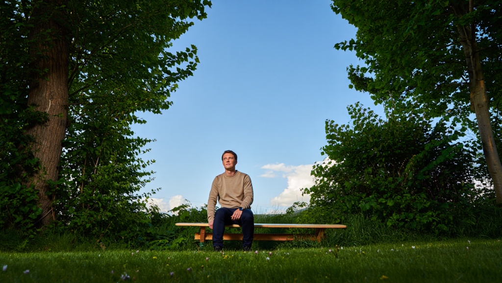 Uomo seduto in ambiente naturale pratica recupero mentale per energia cognitiva